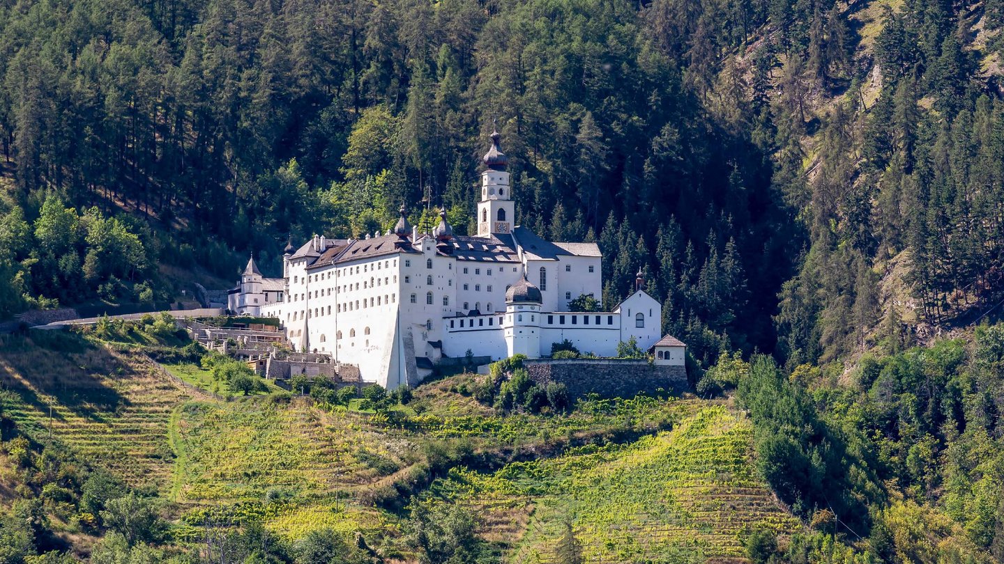 Das Kloster Marienberg, eingebettet in die grüne Landschaft Südtirols, thront majestätisch auf einem Hügel umgeben von Weinbergen.